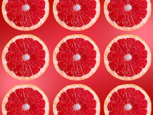 Grapefruit slices on red background