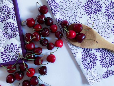 Cherries with wooden spoon top view