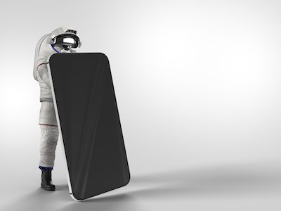 Astronaut behind large iphone on white background.