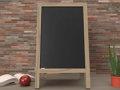 3D Blackboard on easel with apple and open book on wooden background
