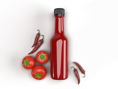 Hot tomato sauce bottle with tomatoes and chilies top view on white background.