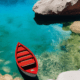 Red boat top view - Red boat floating on clear sea stock image.