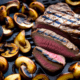 Sliced grilled steak - Grilled steak with grilled mushrooms stock image.