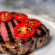 Grilled steak with tomato slices - Grilled steak with tomato slices stock image.