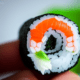 Sushi roll in hand - Sushi roll in hand stock image.